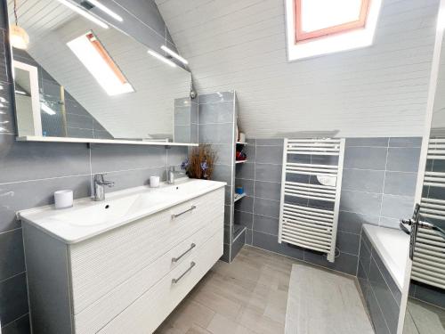 une salle de bain avec un lavabo et un miroir dans l'établissement Maison avec jardin 250m plage, à Batz-sur-Mer