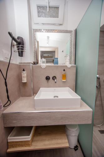 a bathroom with a sink and a mirror at T H E BERLIN Studios and Suites in Nea Vrasna