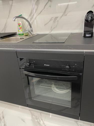 a black oven in a kitchen next to a sink at Luxury 6 al duomo di parma in Parma