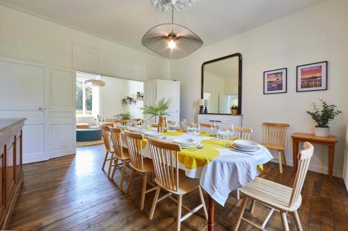 - une salle à manger avec une table, des chaises et un miroir dans l'établissement Le Logis du Clergé - Grande maison pour 15p, à Lassy