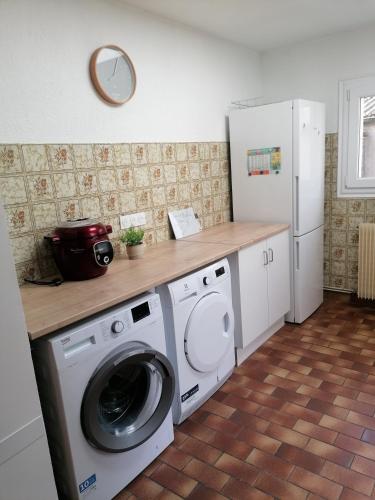 une cuisine avec un lave-linge et un comptoir dans l'établissement Maison le Tréport, à Woincourt