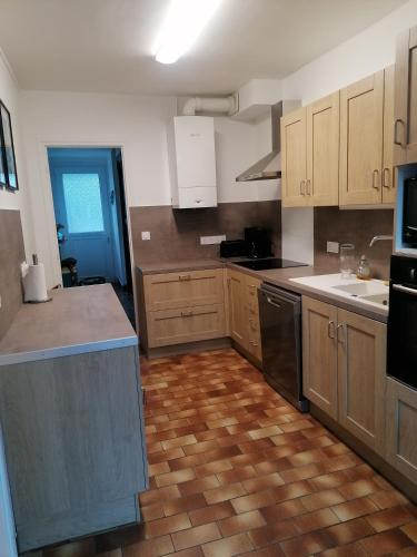 Il comprend une cuisine avec des placards en bois et du parquet. dans l'établissement Maison le Tréport, à Woincourt