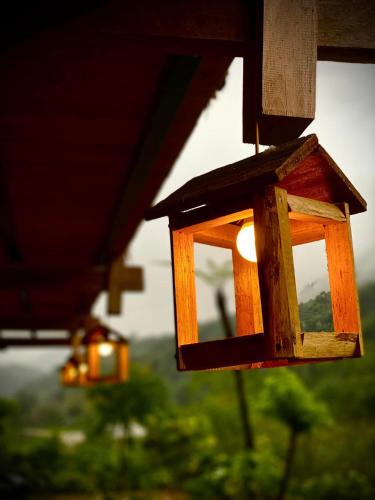 a birdhouse with a light hanging from a roof at Tay Eco House in Ha Giang