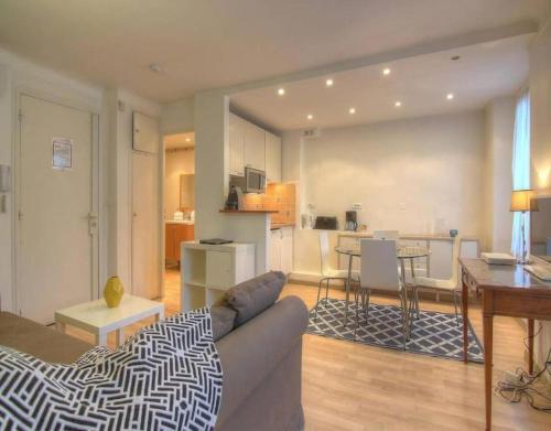 un salon avec un canapé et une cuisine dans l'établissement NEW Cannes Apt - Amazing Location - La Croisette, à Cannes