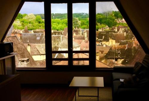 une chambre avec vue sur une ville depuis une fenêtre dans l'établissement Appartement la Belle Vue Panoramique, à Sarlat-la-Canéda