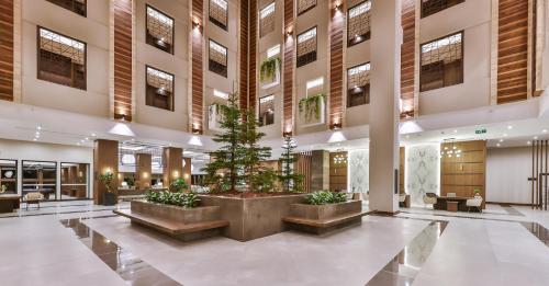 a lobby with a christmas tree in the middle at Narven Wellness & Thermal Hotel in Yukarımahalle