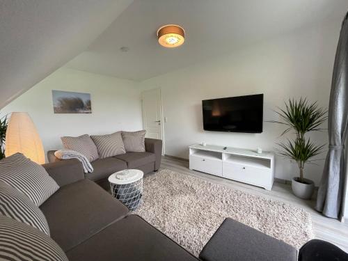 a living room with a couch and a flat screen tv at Ferienwohnung Ahoi in Langwedel