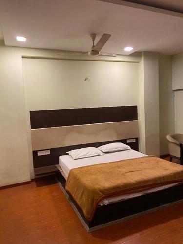 a bedroom with a large bed with a headboard at Hotel Skylark in Nagpur
