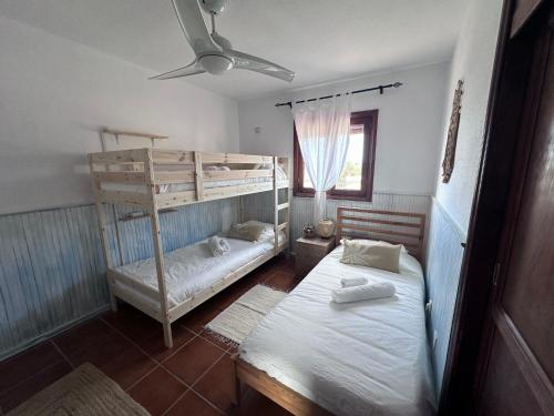 a bedroom with two bunk beds and a window at Dreamwaves Surf House Fuerteventura in La Oliva