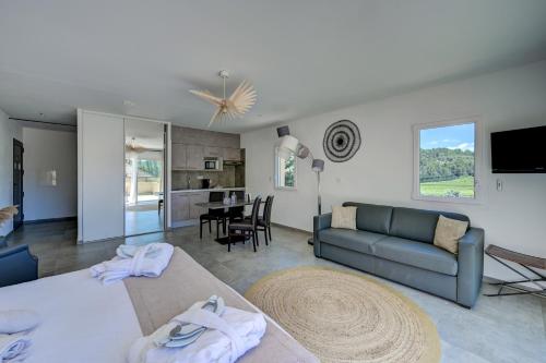 a living room with two beds and a couch at Clos Saint-Michel Resort & Spa in Malaucène