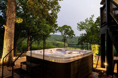 a jacuzzi tub on a patio with a tree at Jesse James and Billy the kid in Hermann