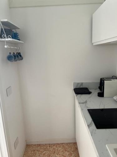 a kitchen with white walls and a counter top at Favolosa Suite con Terrazzo in Vicenza