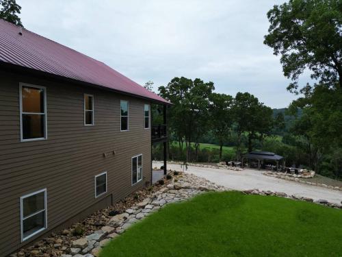a house with a grass yard next to a building at Jesse James and Billy the kid in Hermann