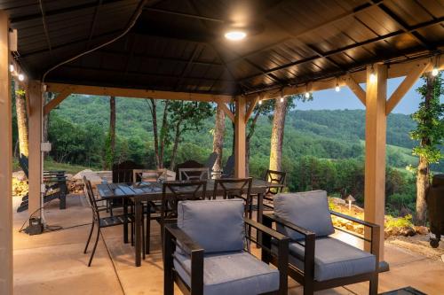 a patio with tables and chairs and a view of the mountains at Bonnie n Clyde and Jesse James in Hermann