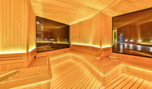an empty sauna with wooden floors and a large window at Narven Wellness & Thermal Hotel in Yukarımahalle