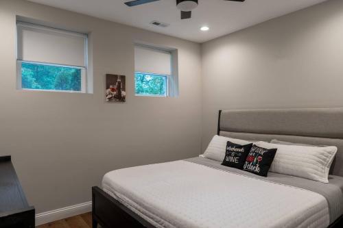 a bedroom with a bed and two windows at Entire Hermann Hideout in Hermann