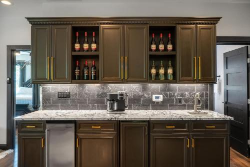 a kitchen with brown cabinets and bottles of wine at Bonnie n Clyde and Jesse James in Hermann