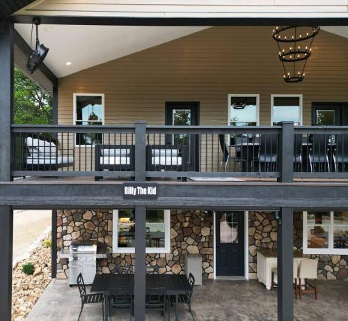 a house with a deck with tables and chairs at Entire Hermann Hideout in Hermann