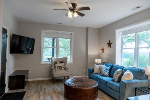 a living room with a blue couch and a ceiling fan at Entire Hermann Hideout in Hermann