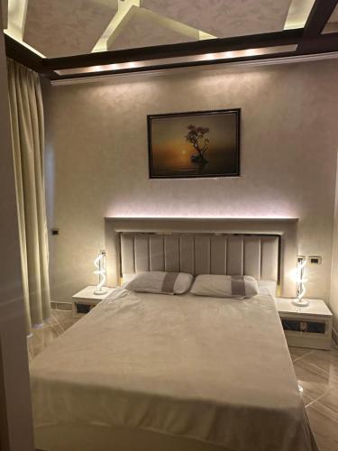 a bedroom with a large bed with two lamps on tables at Sahl Hasheesh, El Andalous by sea and pool view, private beach in Hurghada