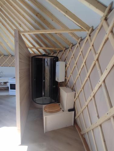 une chambre avec toilettes et télévision dans un mansarde dans l'établissement Chaleureuse yourte a la campagne, à Mourens