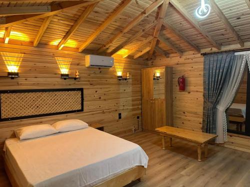 a bedroom with a bed and a wooden wall at YUSUF KARGI - Günübirlik Turizm VİLLA in Ordu