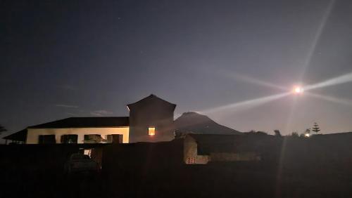 a house at night with the sun rising behind it at Solar dos limas in Criação Velha