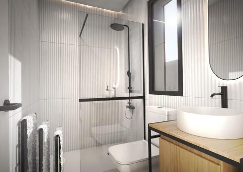 a bathroom with a sink and a toilet and a mirror at Poniente Beach House in Chiclana de la Frontera