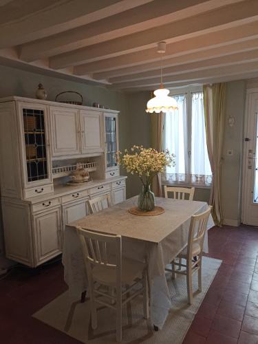 une cuisine avec une table avec un vase de fleurs dessus dans l'établissement Petite Chérie, à Mondoubleau