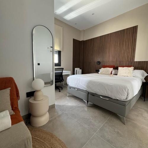 a bedroom with a large bed and a mirror at Poniente Beach House in Chiclana de la Frontera