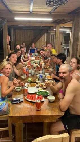 a group of people sitting around a table eating food at Tay Eco House in Ha Giang