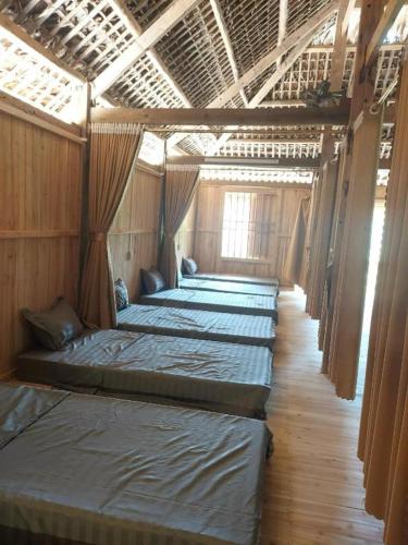a row of beds are lined up in a room at Tay Eco House in Ha Giang