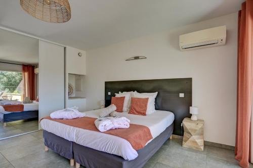 a bedroom with a bed with pink towels on it at Clos Saint-Michel Resort & Spa in Malaucène