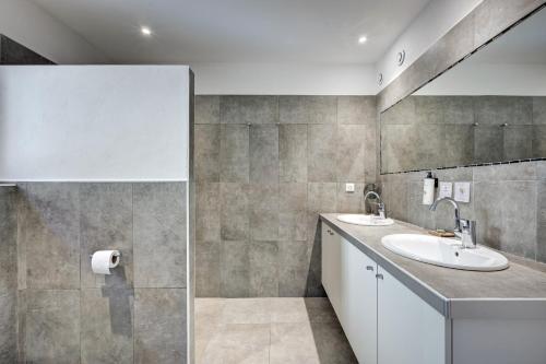 a bathroom with two sinks and a mirror at Clos Saint-Michel Resort & Spa in Malaucène