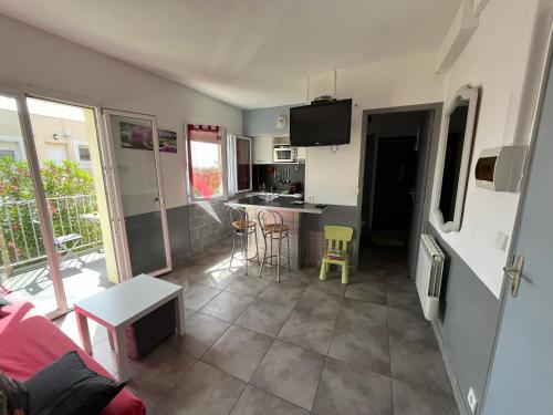 une cuisine et un salon avec un canapé et une table dans l'établissement Appartement à 20 m de la plage, à Frontignan