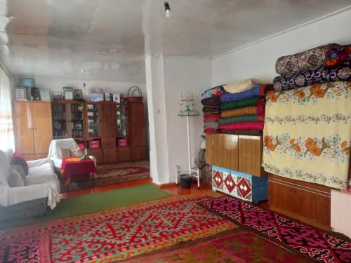 ein Wohnzimmer mit einem Bett und einem Teppich in der Unterkunft Акбермет in Bokonbayevo