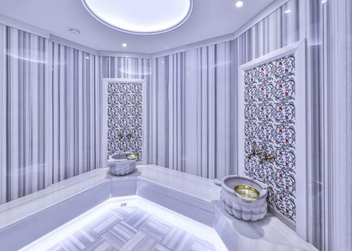 a bathroom with a tub and two stools at Narven Wellness & Thermal Hotel in Yukarımahalle