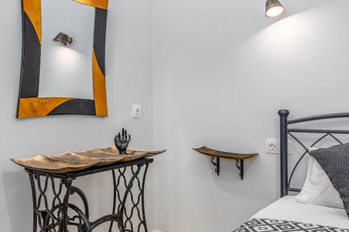 a bedroom with a bed and a table and mirrors at Riviera Apartment in Benitses