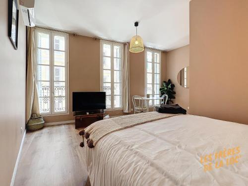 een slaapkamer met een groot bed en een flatscreen-tv bij Magnifique Studio - Hyper Central & Climatisation - Les Frères de la Loc' in Marseille