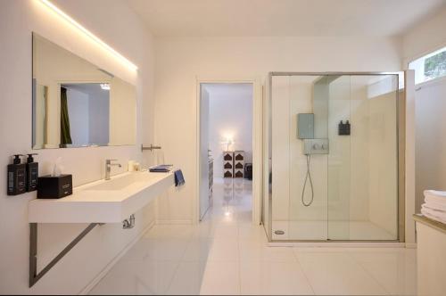 a white bathroom with a shower and a sink at La Casa E Il Mare, Private Bay Hotel in Mattinata
