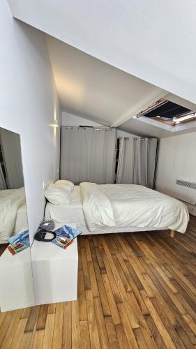une chambre avec deux lits et un parquet dans l'établissement Appartement Boulogne-Billancourt, à Boulogne-Billancourt