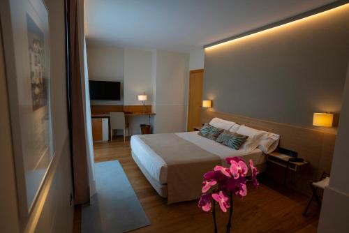 a hotel room with a bed with pink flowers on it at Hotel Jaizkibel in Hondarribia