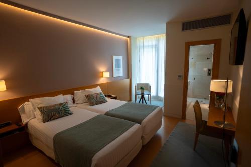 a hotel room with two beds and a television at Hotel Jaizkibel in Hondarribia