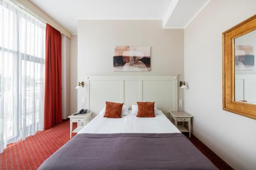 a bedroom with a bed with two pillows at Europa Royale Druskininkai in Druskininkai