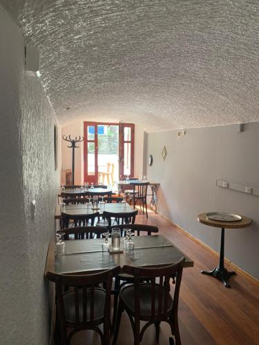 een rij tafels en stoelen in een kamer bij Café du Commerce in Génolhac
