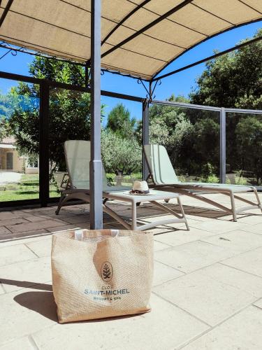 a pair of chairs and a bag on a patio at Clos Saint-Michel Resort & Spa in Malaucène