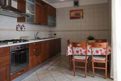 Una cocina con gabinetes de madera y una mesa con sillas. en Casa di Laura, en Monopoli