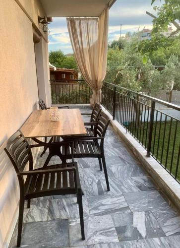 a wooden table and two chairs on a balcony at Dili Apartments in Ierissos