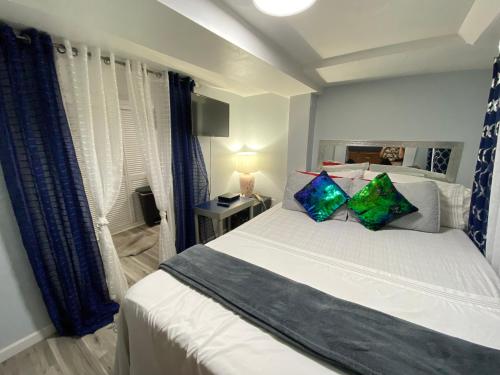 ウエスト・ニューヨークにあるOasis in New Jersey - 2BR NYC Accessのベッドルーム(大きな白いベッド、カラフルな枕付)