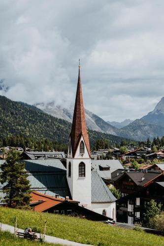 a church with a steeple on top of a town at Post Seefeld - Wellnesshotel Tirol in Seefeld in Tirol